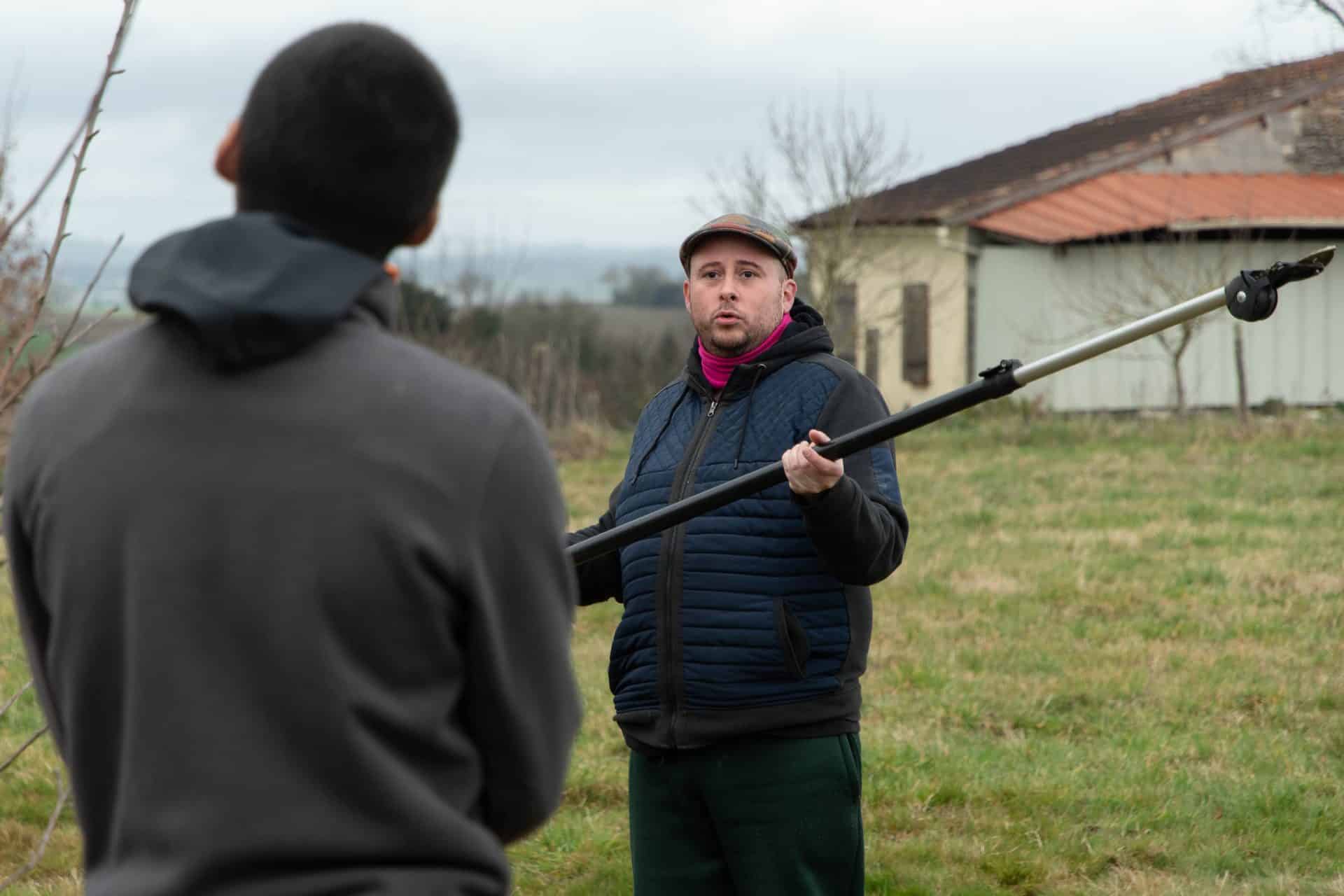 un formateur explique au groupe de jeunes comment fonctionnent les outils pour tailler les arbres en formations longues Al’Terre Égaux